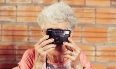 Une dame âgée tenant un appareil photo