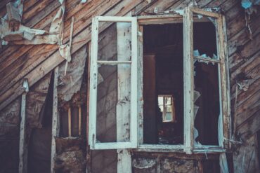 Une maison en bois avec une fenêtre calcinée.