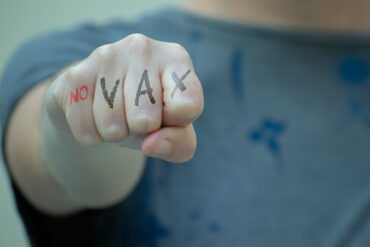Un poing brandit avec l'inscription no VAX.